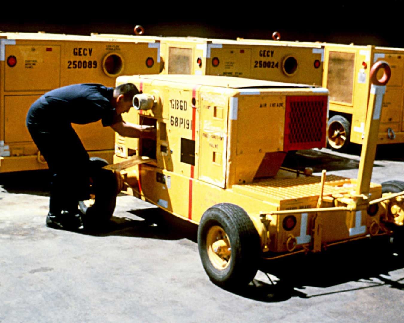 A member of the Aircraft Intermediate Maintenance Department (AIMD) support equipment section checks pump hoses on a demineralization cart