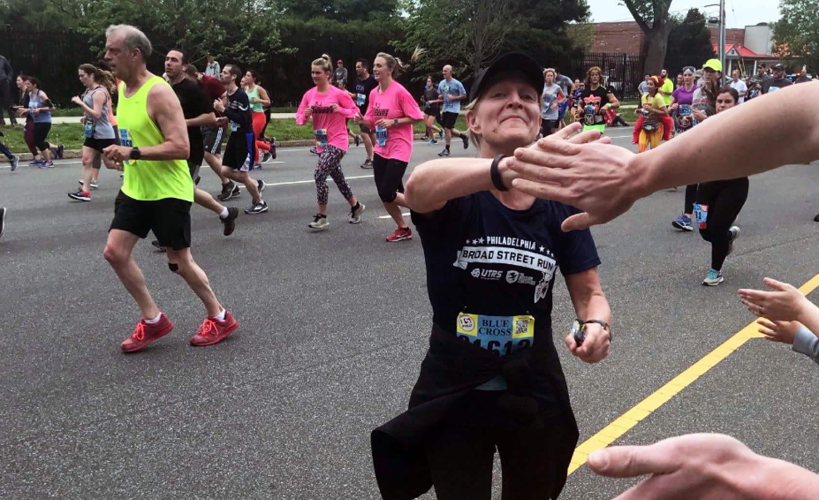 UTRS employee participating in Philadelphia Broad Street Run and getting support from fellow employees.